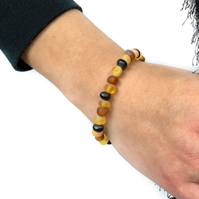 unpolished multi color amber bracelet on hand